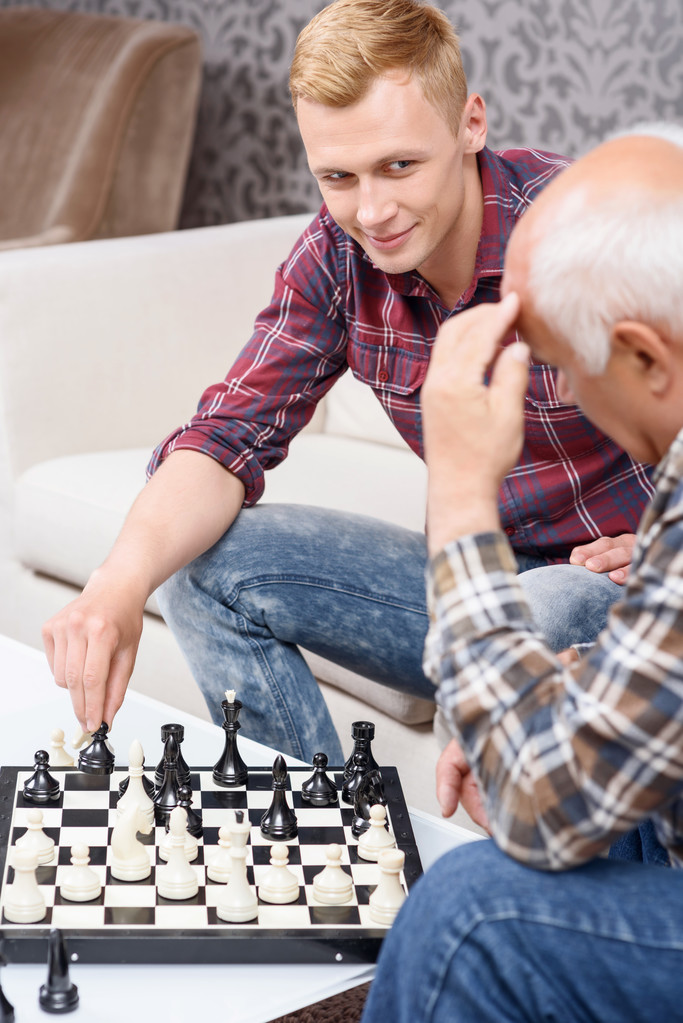 Дедушка и внук играют в шахматы
  - Фото, изображение