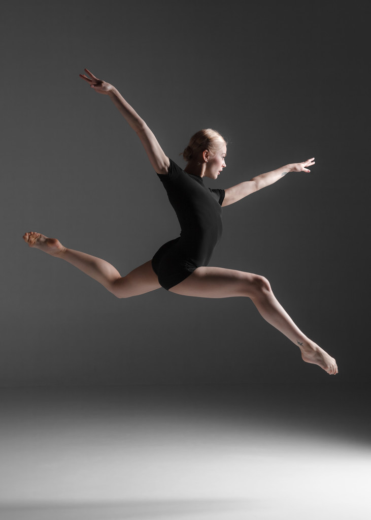 Nuori kaunis moderni tanssija hyppää studion taustalla
 - Valokuva, kuva