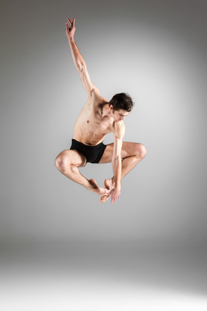 a fiatal, vonzó, modern balett-táncos, ugrás a fehér háttér - Fotó, kép