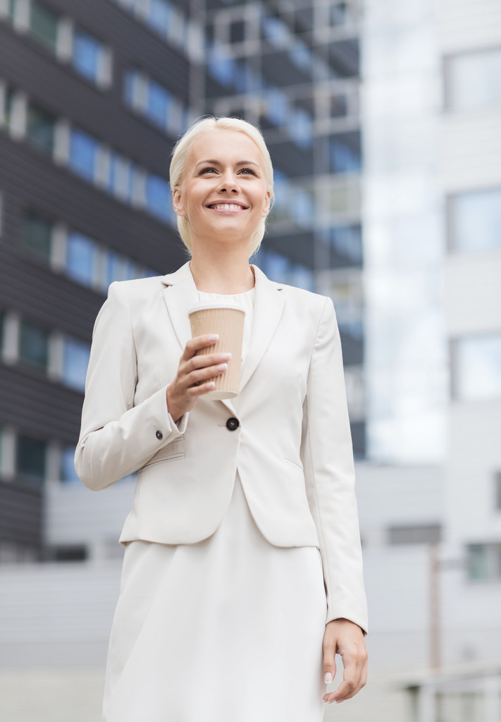 mujer de negocios sonriente con taza de papel al aire libre
 - Foto, imagen