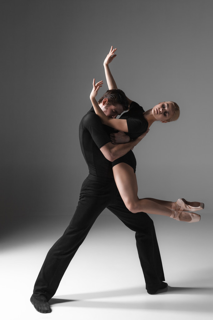 дві молоді сучасні танцюристи балету на сірому фоні студії
  - Фото, зображення