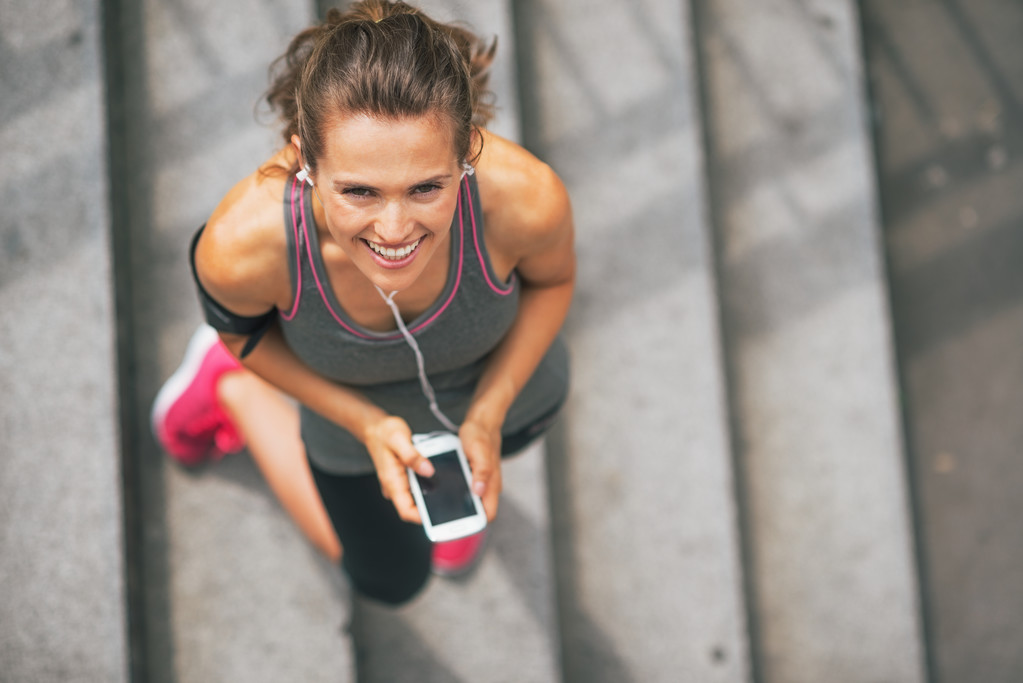 Mosolyogva mobiltelefon kültéri fitness fiatal nő portréja - Fotó, kép