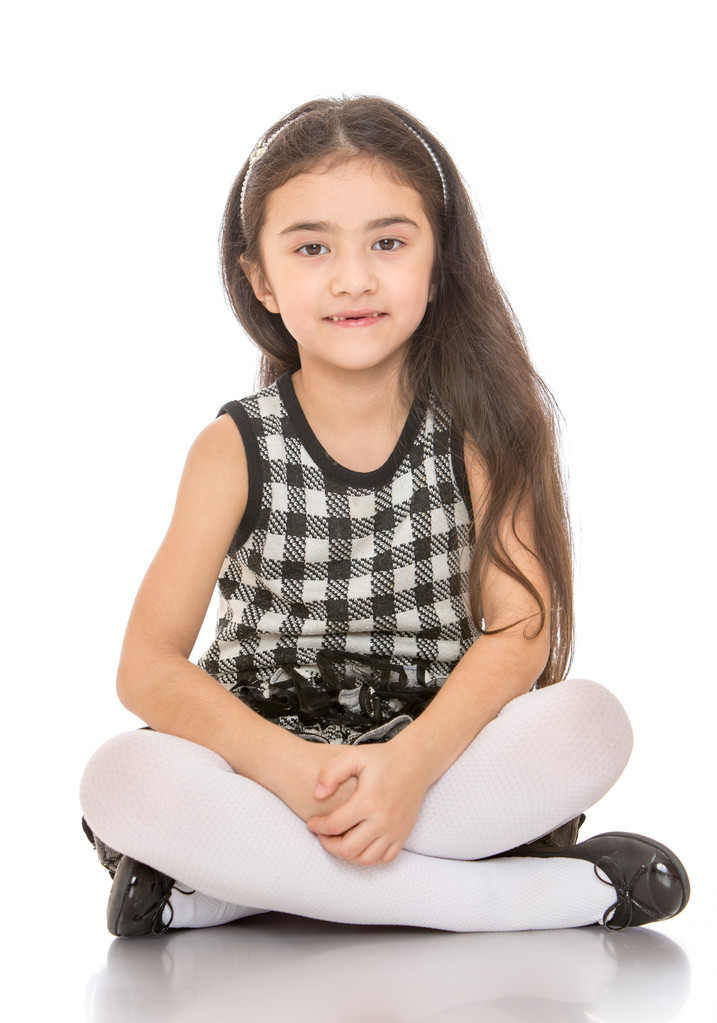 Charming dark-haired little girl sitting on the floor folded in Turkish feet - Photo, Image