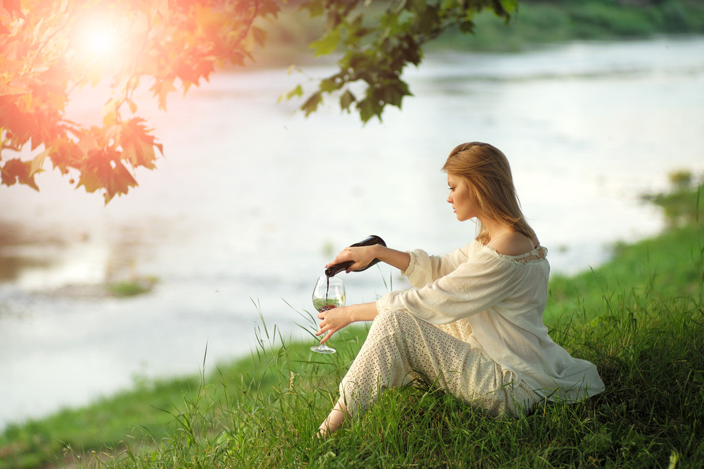 Kaunis nainen auringonlaskussa lähellä jokea
 - Valokuva, kuva