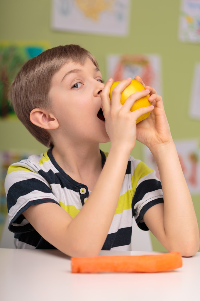 маленька дитина їсть смачне яблуко
 - Фото, зображення