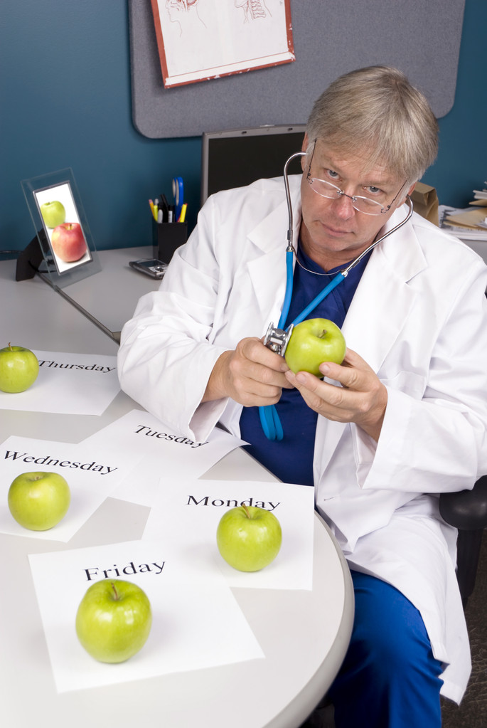 lekarz bada jabłko - Zdjęcie, obraz
