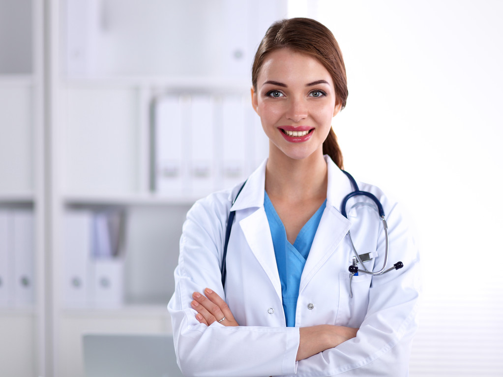 Retrato de jovem médico com casaco branco em pé no hospital - Foto, Imagem