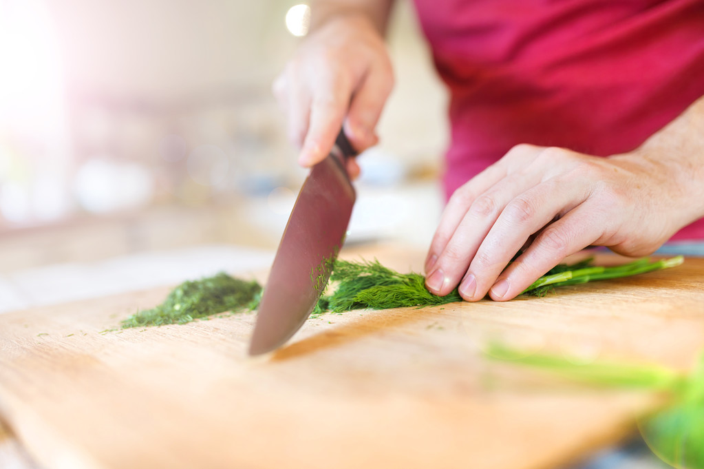 Человек на кухне режет укроп
 - Фото, изображение