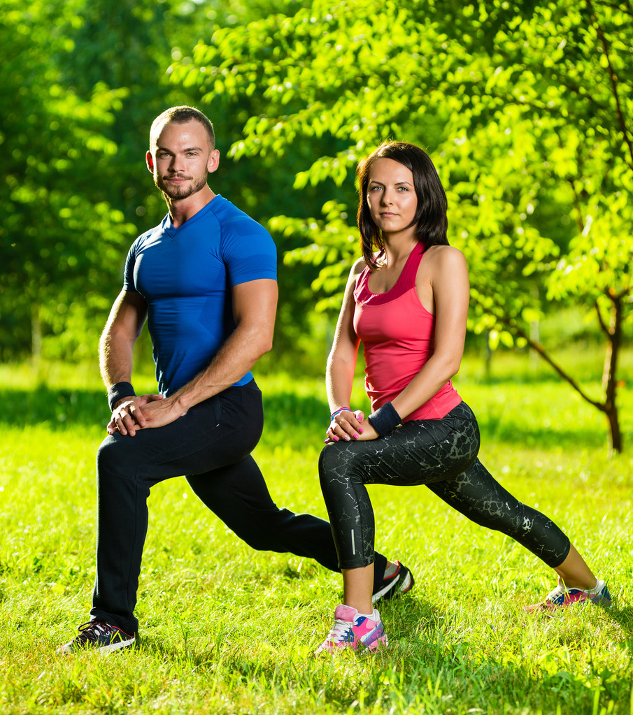 Uomo e donna che fanno esercizi di stretching - Foto, immagini
