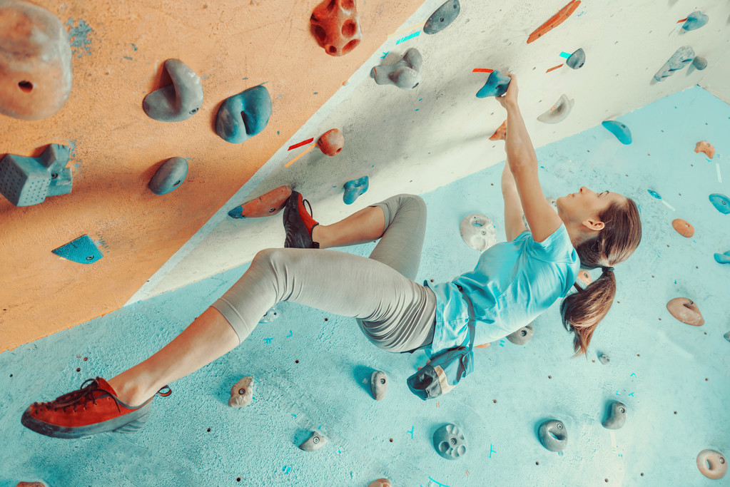 young woman training in climbing gym. - Foto, afbeelding