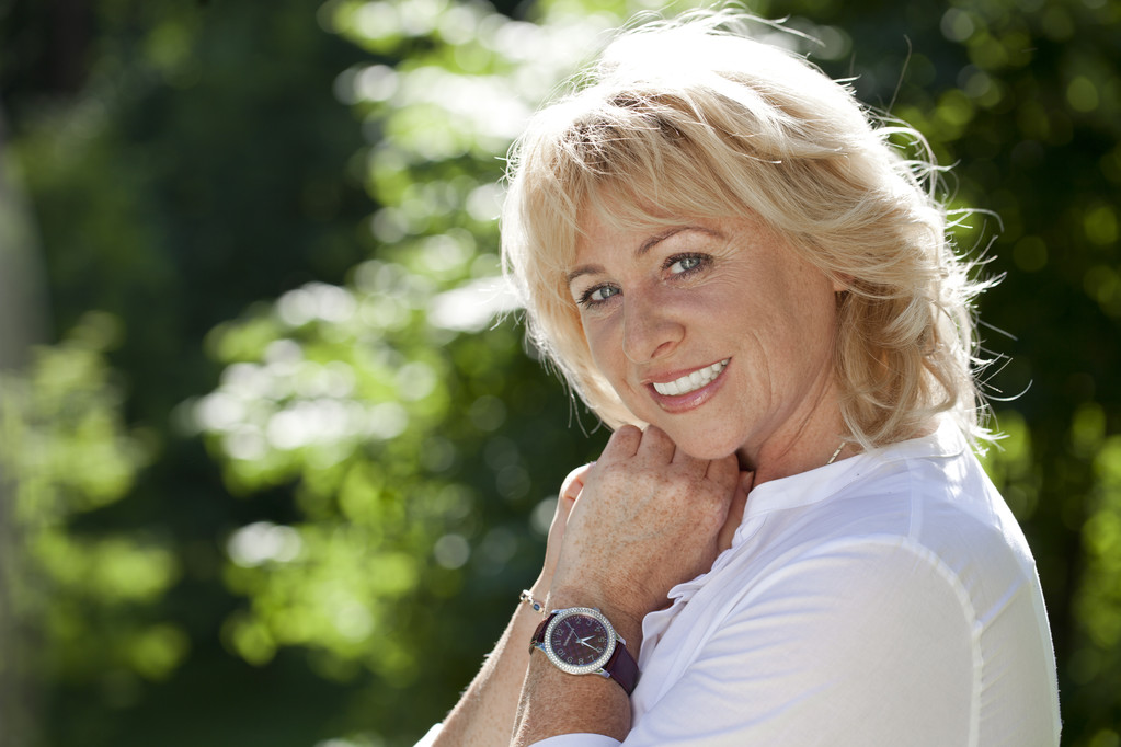Portrait of serene mature woman in the summer park  - Photo, Image
