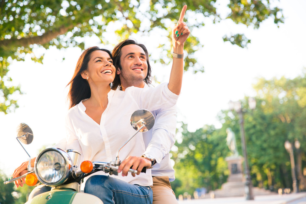Sorridente giovane coppia su scooter insieme
 - Foto, immagini