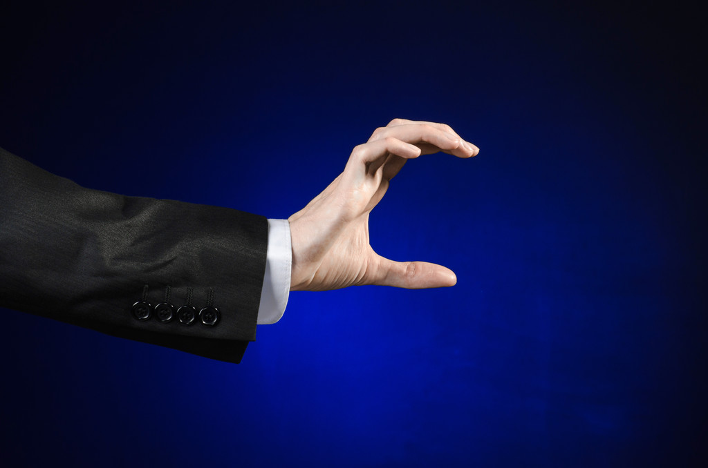 Бізнесмен і тема жесту: чоловік у чорному костюмі та білій сорочці, що показує жест рук на ізольованому темно-синьому фоні в студії
 - Фото, зображення