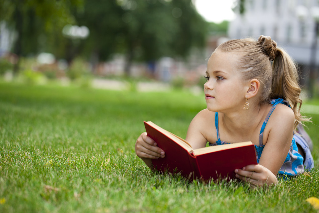 Adorável bonito menina leitura livro fora na grama
 - Foto, Imagem