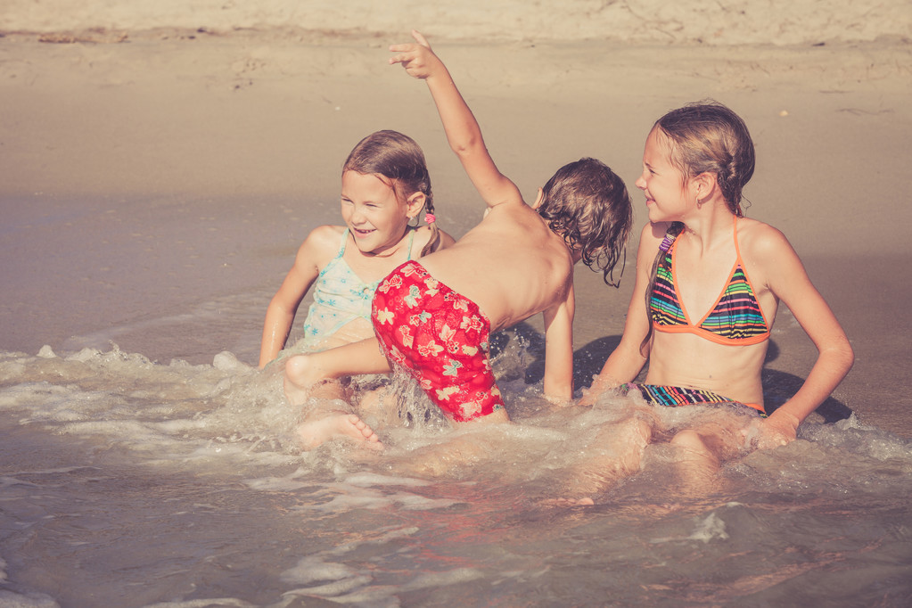 Трое счастливых детей играют на пляже
 - Фото, изображение