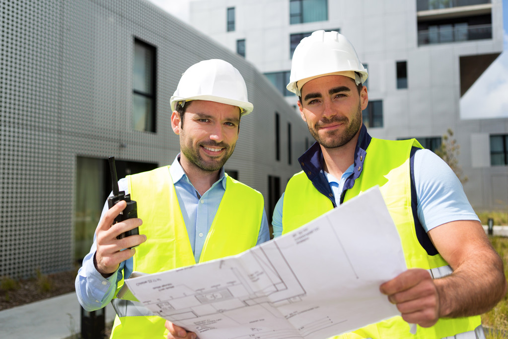 Engineer and worker checking plan on construction site  - Photo, Image