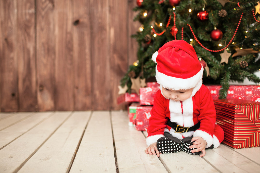 Baby im Weihnachtsmannanzug mit Geschenken in der Nähe des Weihnachtsbaums - Foto, Bild