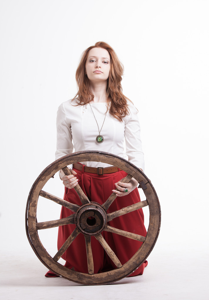 young woman with an old wagon wheel - Photo, Image
