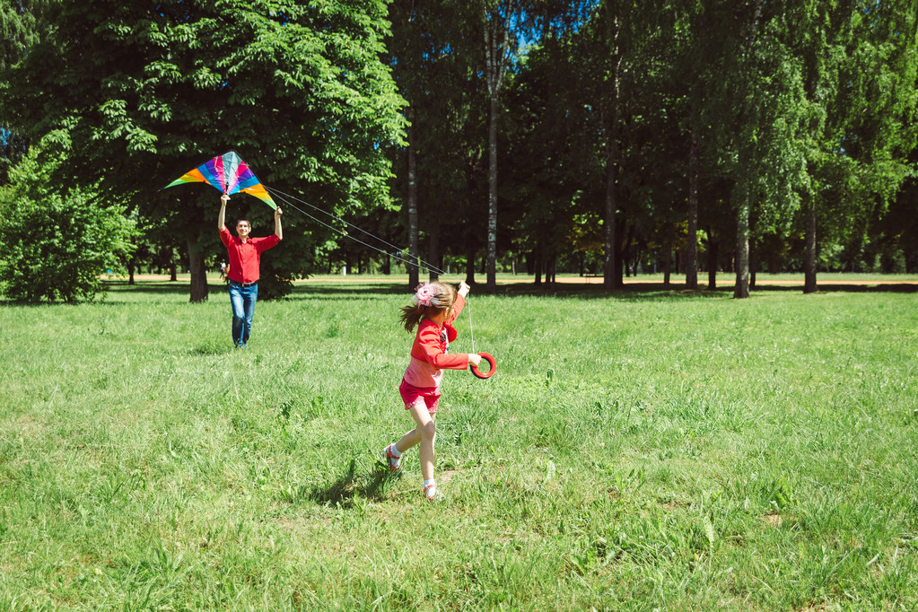 Дівчина і її батько грають з повітряним змієм
. - Фото, зображення