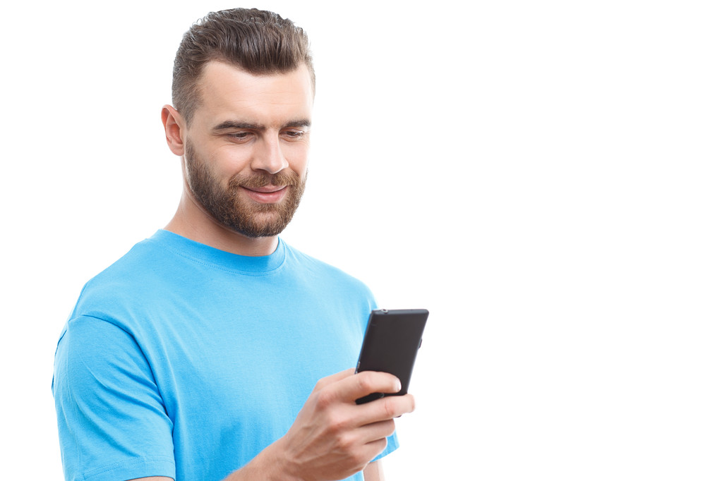Чоловік з бородою тримає мобільний телефон
 - Фото, зображення