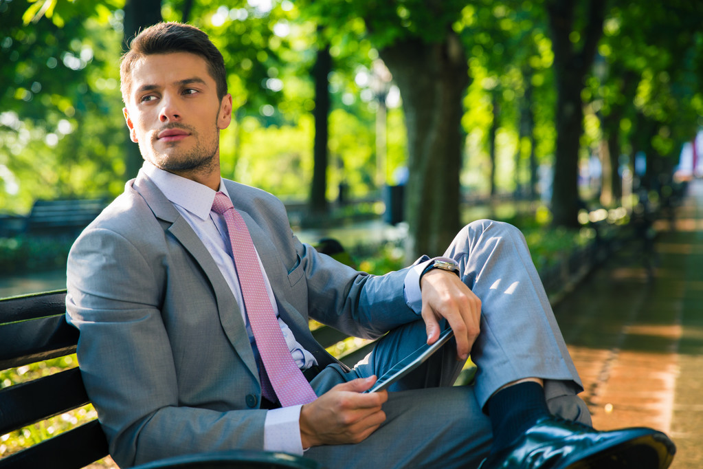Businessman sitting on the bench with tablet computer  - Photo, Image