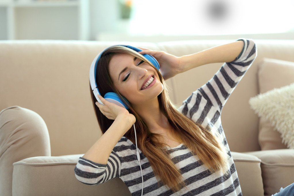 Frau hört Musik über Kopfhörer im Zimmer - Foto, Bild