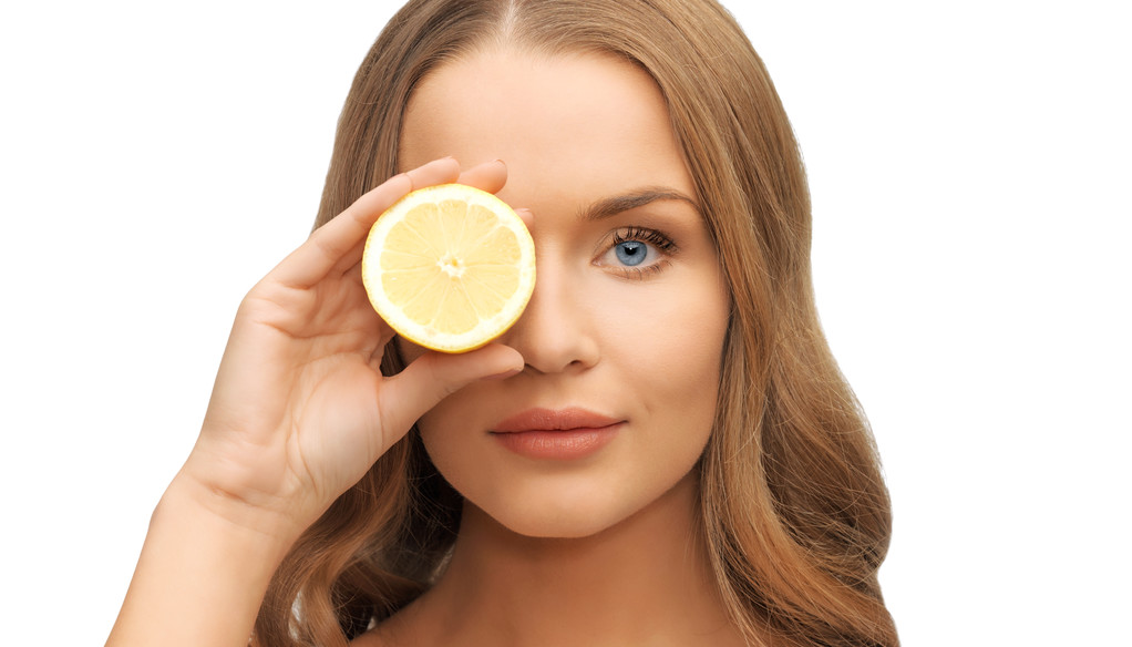 beautiful woman face with lemon slice over eye - Fotoğraf, Görsel