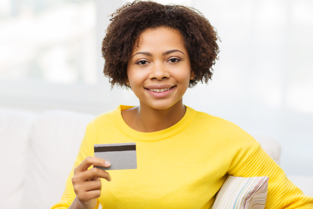 Gelukkig Afrikaanse vrouw met creditcard of bankkaart - Foto, afbeelding