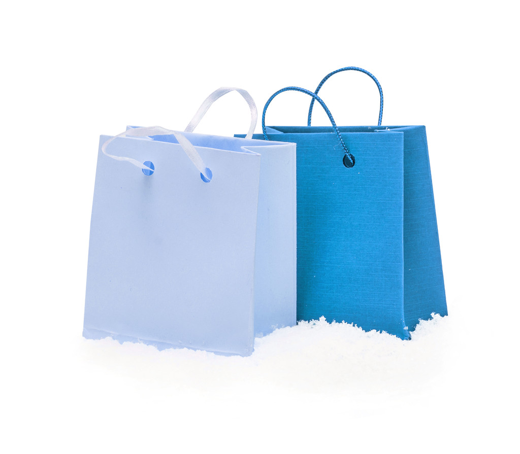 青いギフト パッケージは、白で隔離雪の上スタンドします。 - 写真・画像