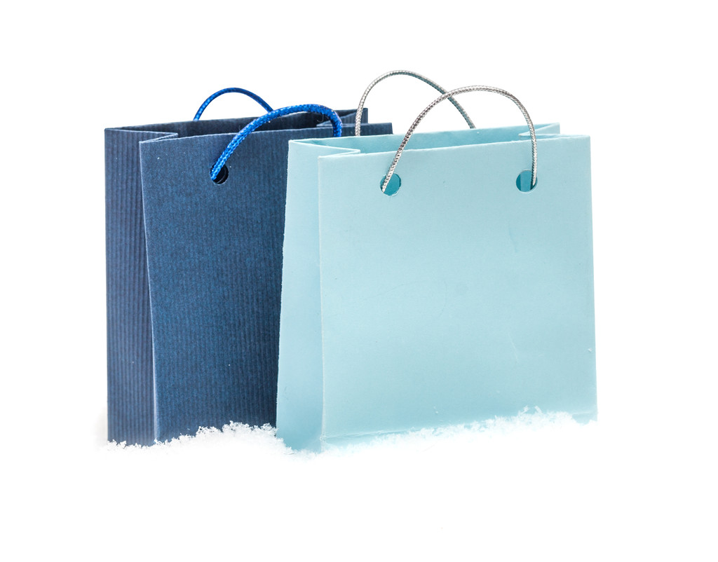 Синій подарунковий пакет коштує на снігу, ізольований на білому
 - Фото, зображення