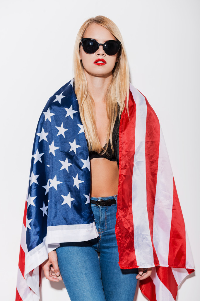 woman covering her shoulders by American flag - Foto, afbeelding