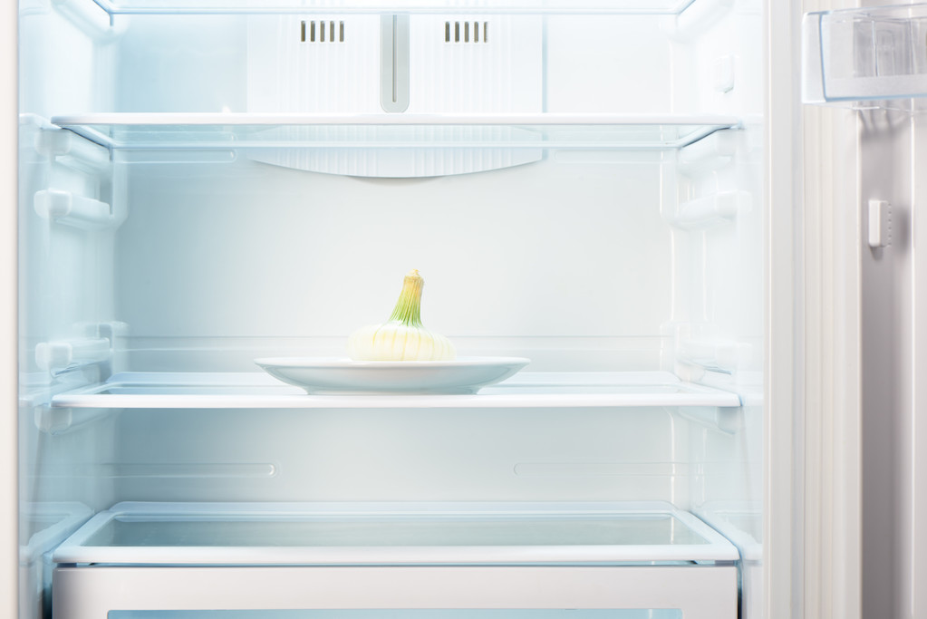 Bílé cibule na bílém štítku v otevřených prázdné ledničce - Fotografie, Obrázek