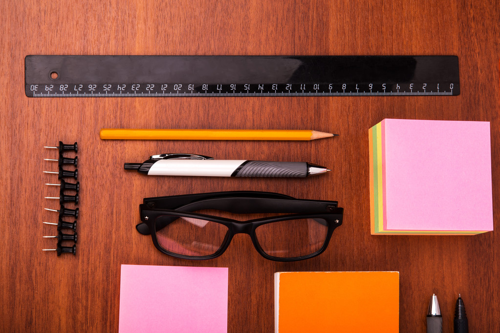 Escritorio de oficina con gafas regla lápiz pluma y otros artículos de oficina
 - Foto, imagen