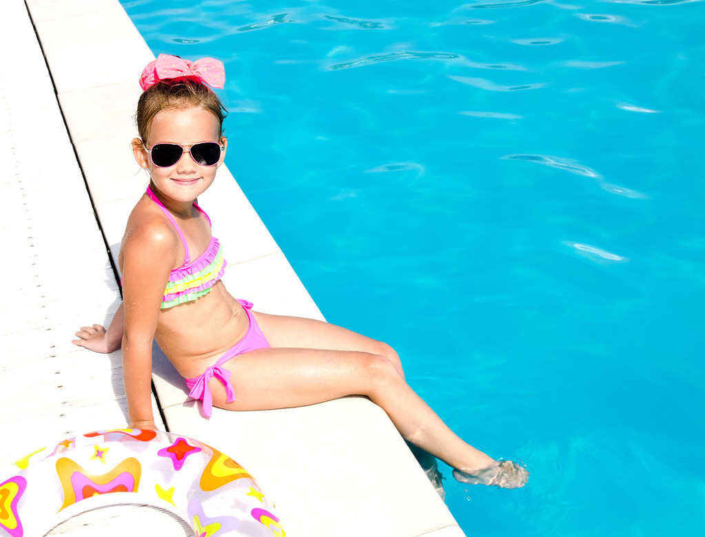 Lachende meisje zitten in de buurt van zwembad  - Foto, afbeelding