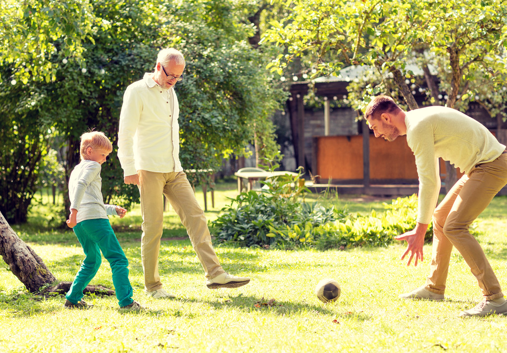 gelukkige familie spelen voetbal buitenshuis - Foto, afbeelding