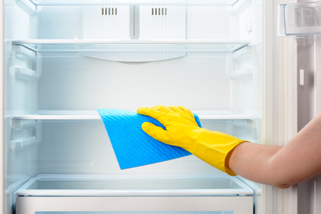 Mano donna in guanto giallo pulizia frigorifero con straccio blu
 - Foto, immagini