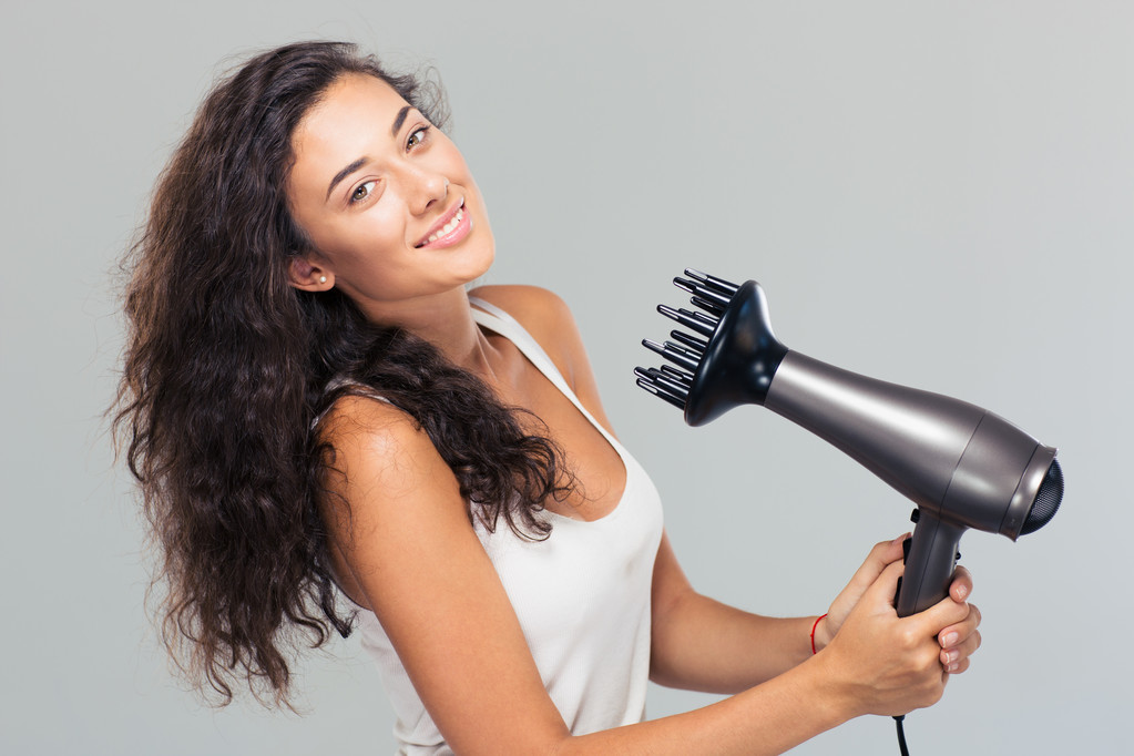 Χαμογελαστά όμορφη γυναίκα στεγνώνει τα μαλλιά  - Φωτογραφία, εικόνα
