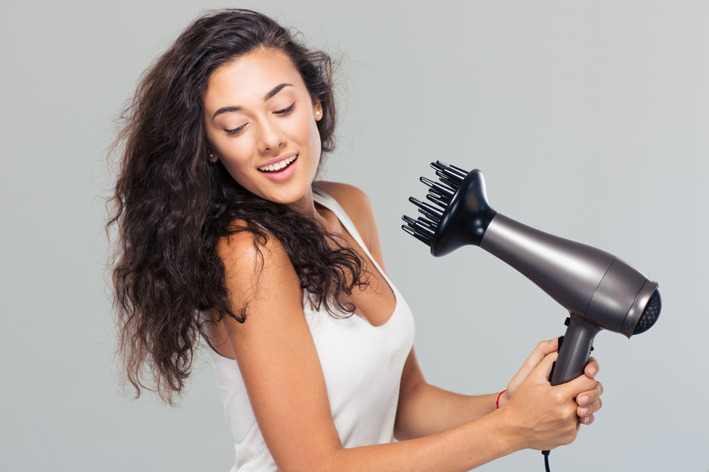 Lächelnde junge Frau trocknet ihr Haar - Foto, Bild