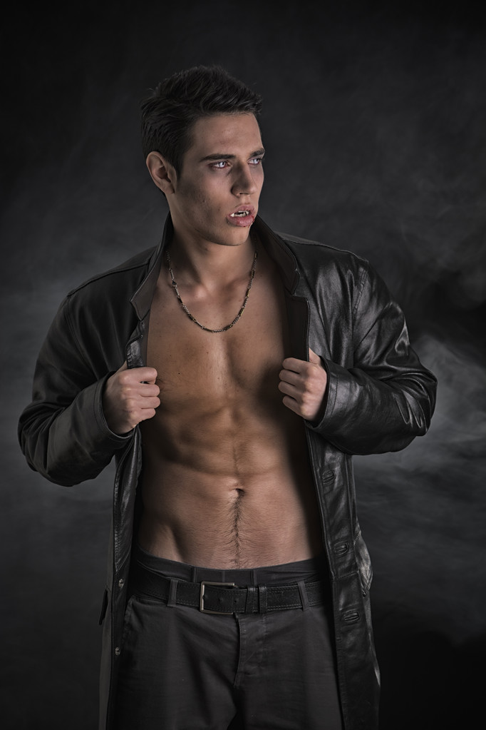 胸と腹筋を示すオープン黒革ジャケットの若い吸血鬼男 - 写真・画像