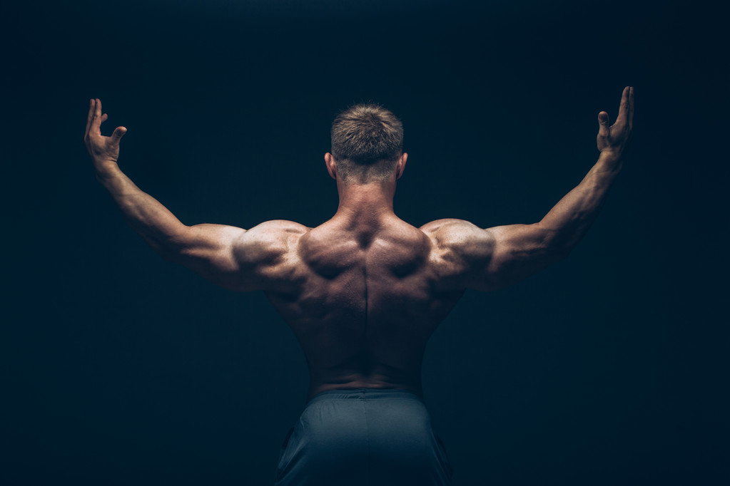 Handsome muscular bodybuilder posing over black background. - Photo, Image