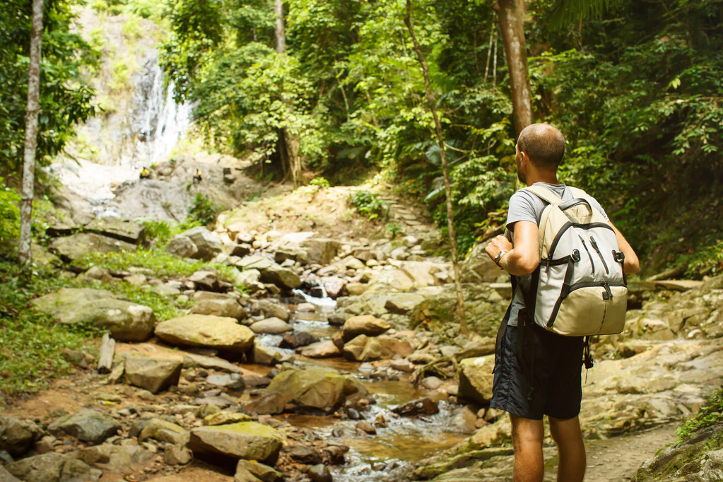 Jeune homme avec un sac à dos de voyage près d'une cascade en Thaïlande
 - Photo, image