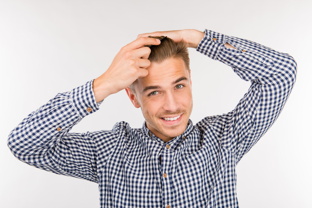 pohledný mladý muž si kartáčuje vlasy - Fotografie, Obrázek