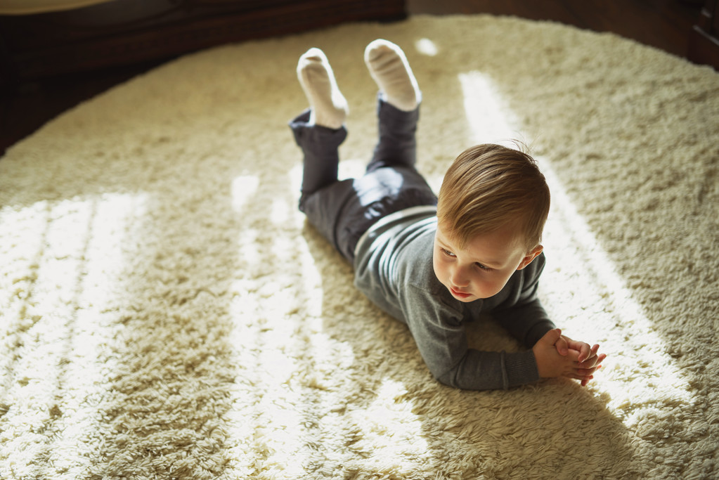 niño pequeño acostado en la alfombra
 - Foto, Imagen
