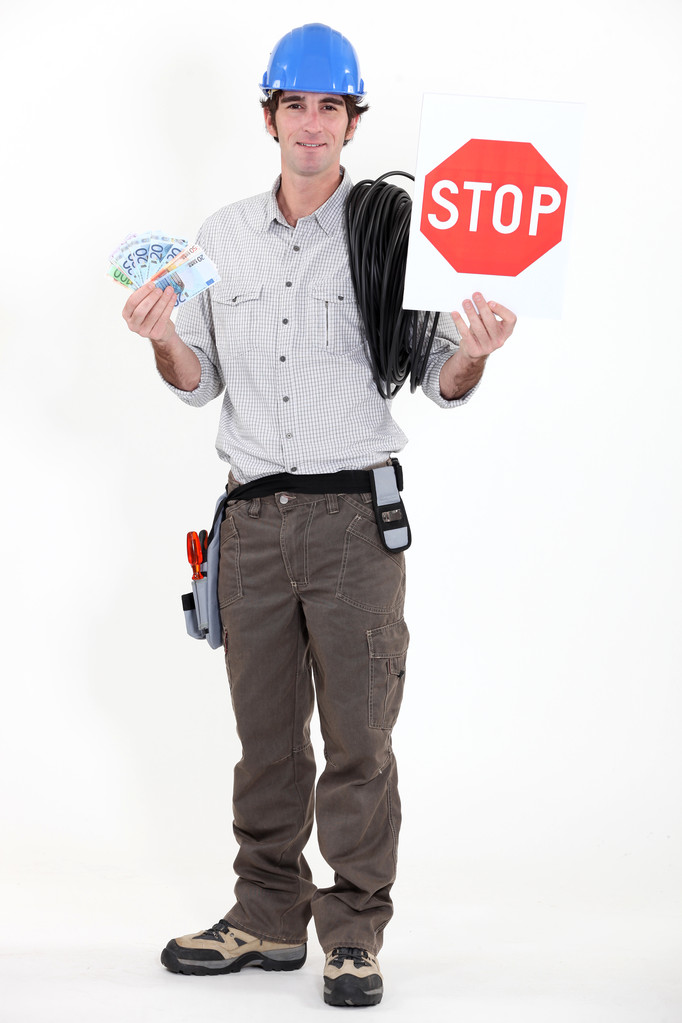 Électricien tenant de l'argent comptant et stop sign
 - Photo, image