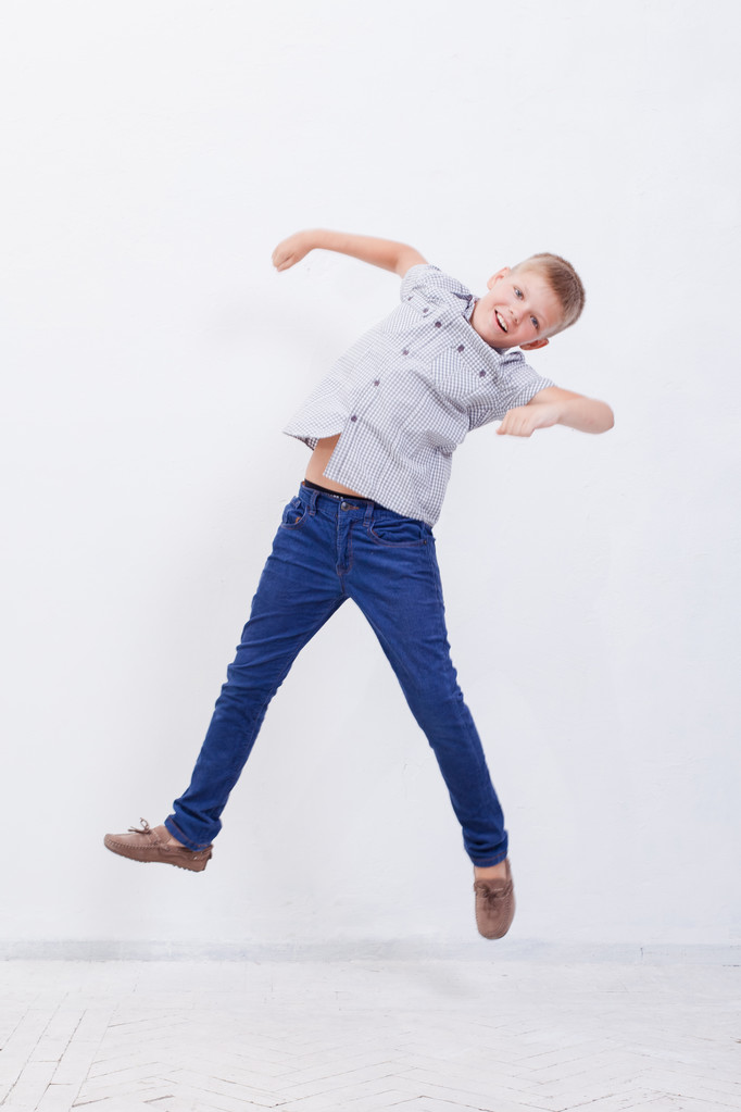 glücklicher kleiner Junge springt auf weißem Hintergrund - Foto, Bild