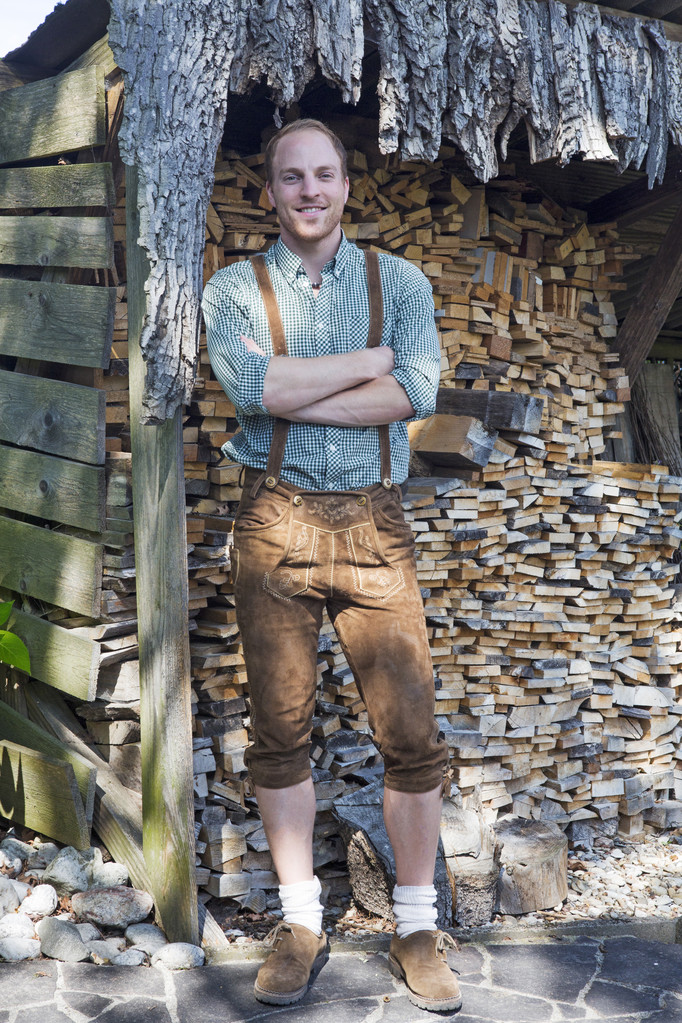 jeune homme en bavarois lederhosen devant le bois de chauffage
 - Photo, image
