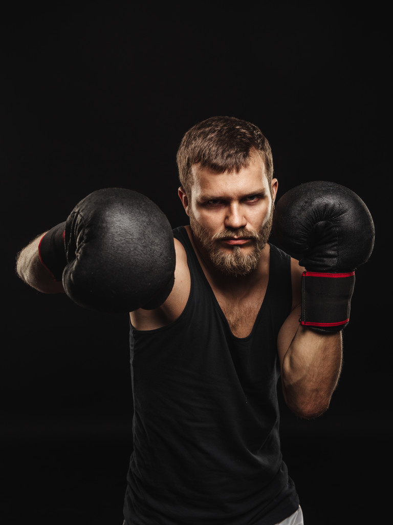 Boxeador atlético barbudo con guantes sobre fondo oscuro
 - Foto, Imagen