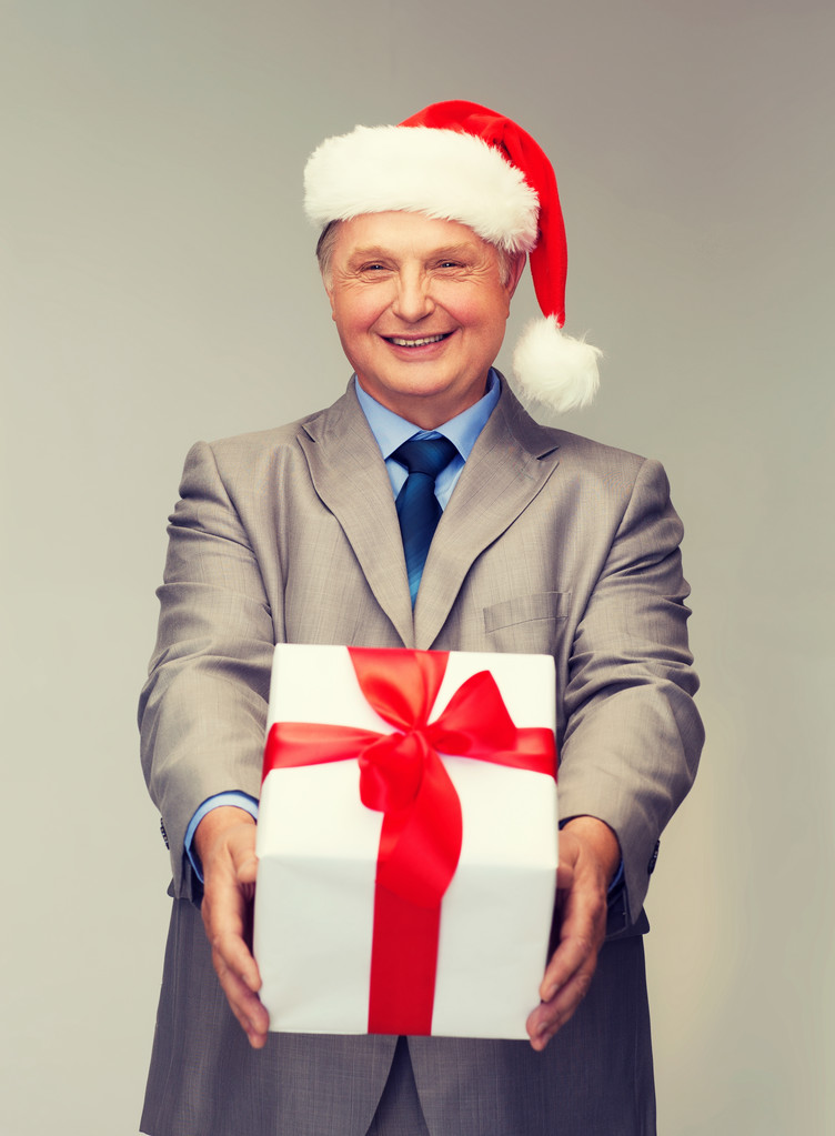 Усміхнений чоловік у костюмі та капелюсі Санти з подарунком
 - Фото, зображення