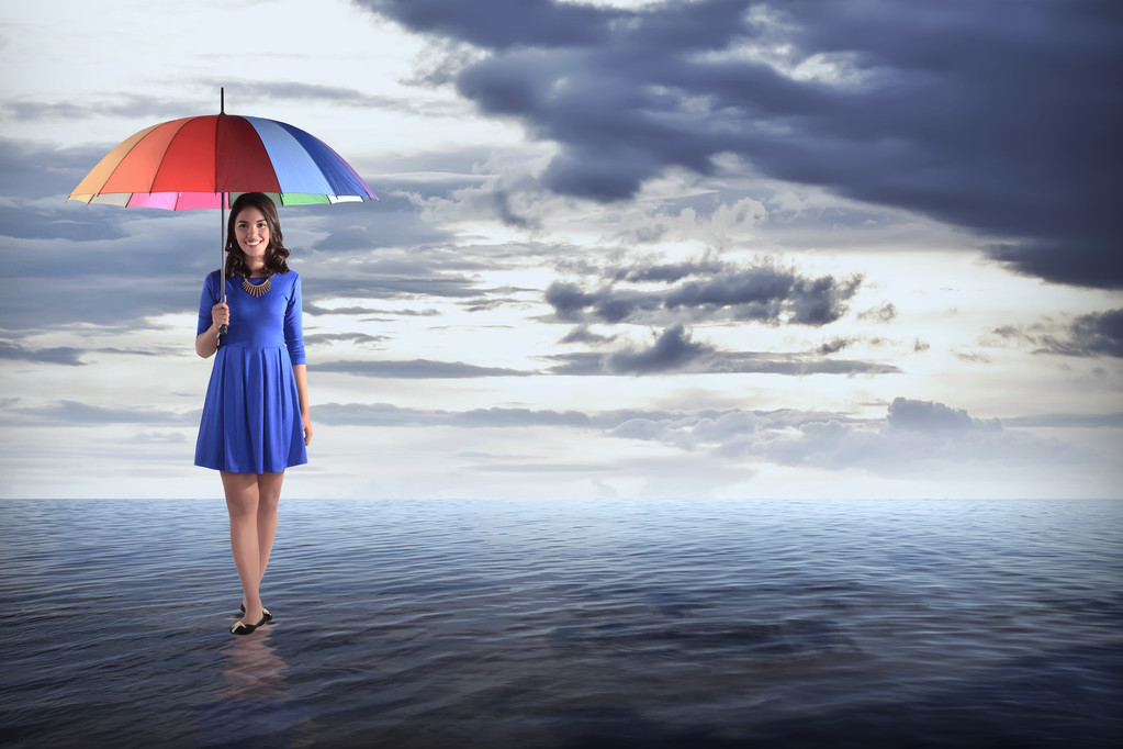 Жінка тримає парасольку на морі - Фото, зображення