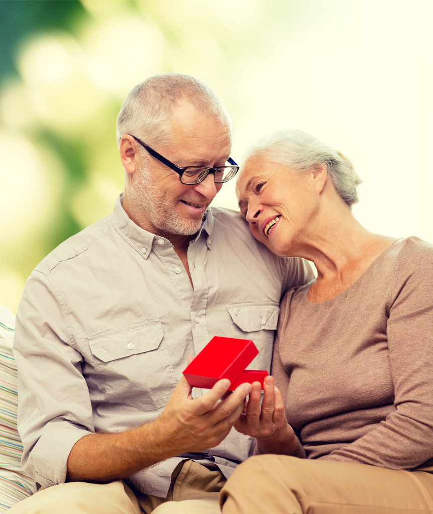 feliz pareja de ancianos con caja de regalo roja
 - Foto, imagen
